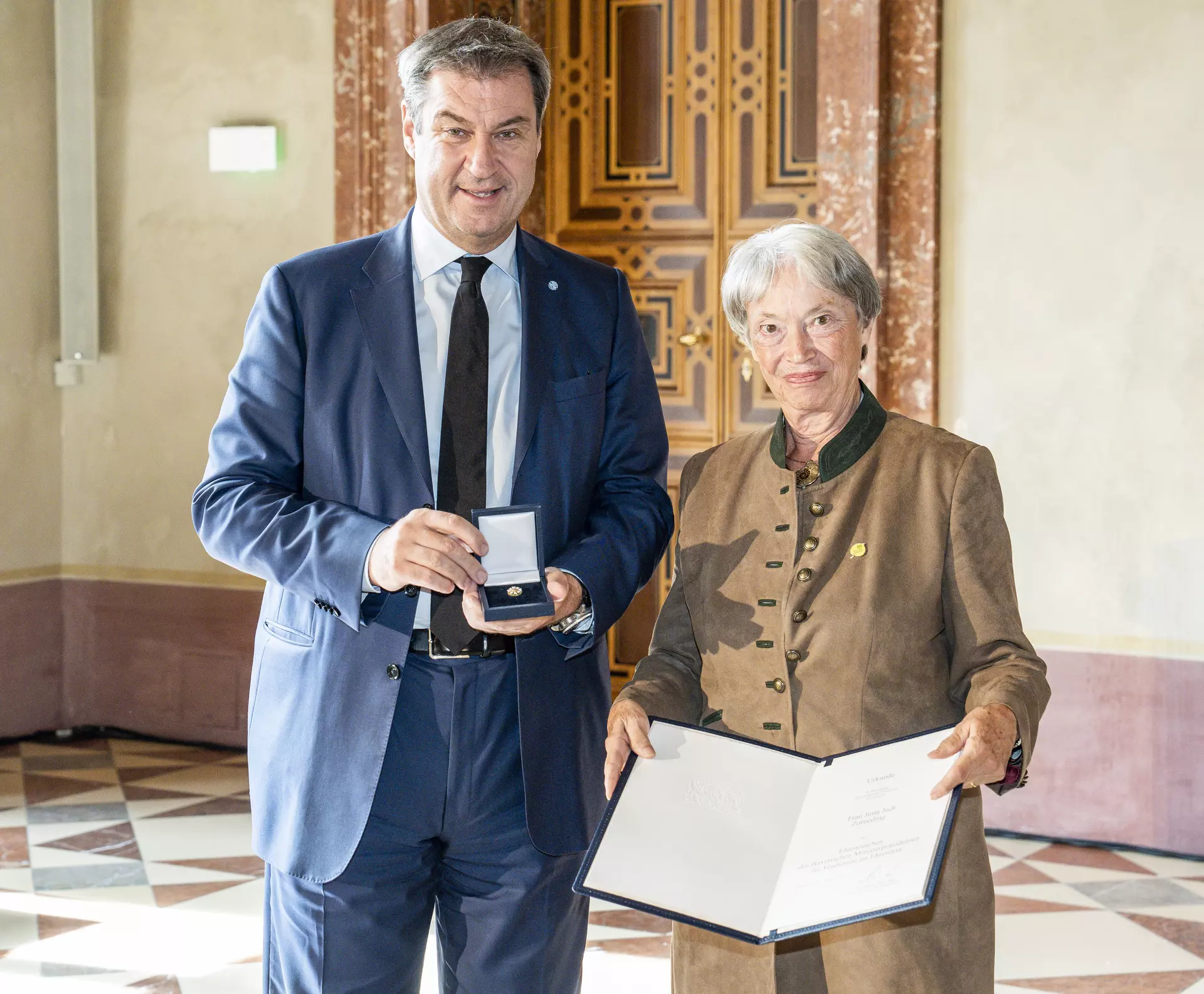 Ehrenzeichen für Jutta Judt, Ministerpräsident Markus Söder und Jutta Judt in der Münchner Residenz